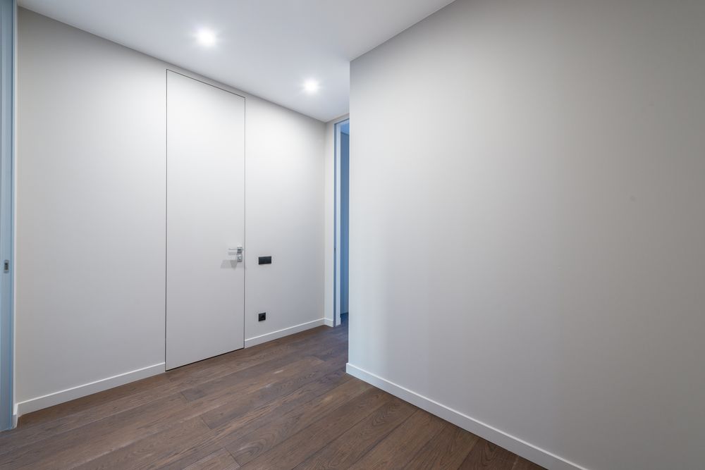 A renovated Fort Rouge room with a dark plank floor running out through a doorway.